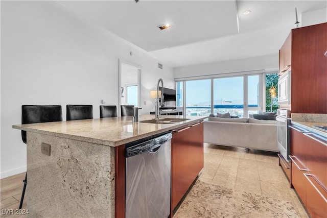 4471 Dean Martin Dr Unit 606, Las Vegas, NV 89103 - kitchen featuring stainless steel dishwasher, wall oven, open floor plan, a breakfast bar area, and light stone counters