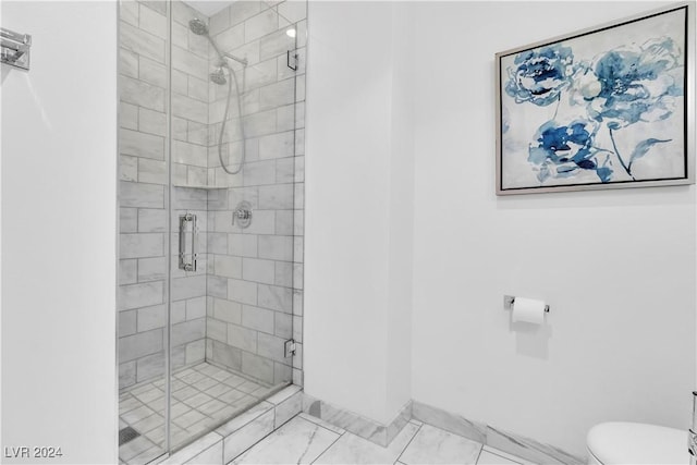 bathroom featuring toilet and a shower with shower door