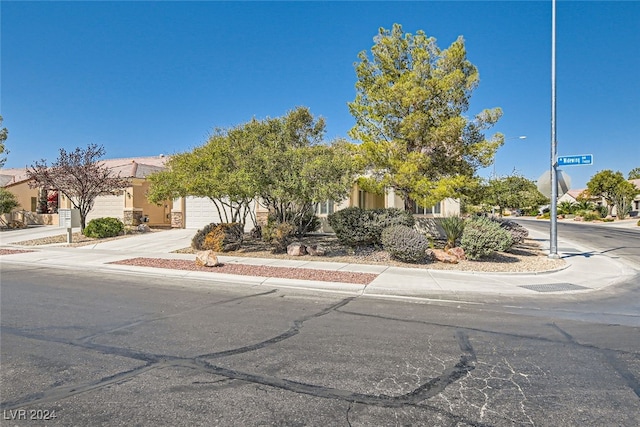 view of property hidden behind natural elements featuring a garage