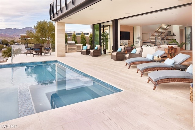 view of pool featuring a patio, a mountain view, an outdoor living space, and a hot tub