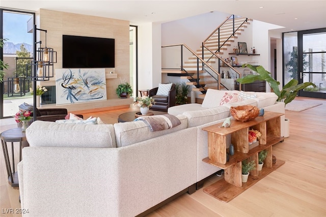 living room featuring wood-type flooring, plenty of natural light, and floor to ceiling windows