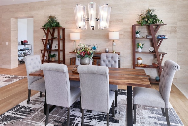 dining area with a notable chandelier and hardwood / wood-style floors