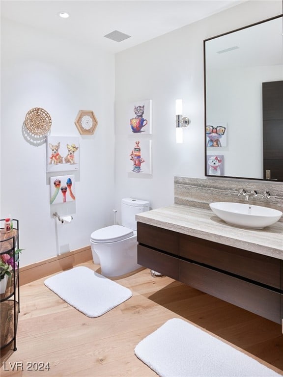 bathroom featuring hardwood / wood-style flooring, vanity, and toilet