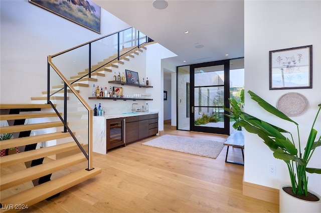 4915 Summit Overlook Dr, Las Vegas, NV 89135 - stairway featuring a dry bar, wine cooler, wood finished floors, and a wall of windows