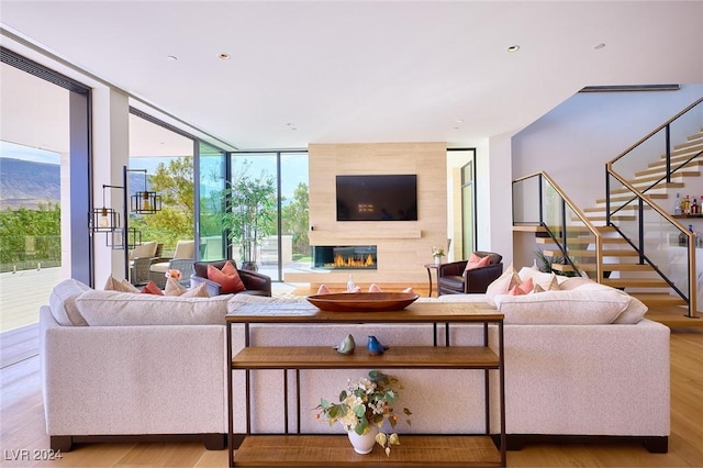 4915 Summit Overlook Dr, Las Vegas, NV 89135 - living area featuring floor to ceiling windows, a large fireplace, stairway, and wood finished floors