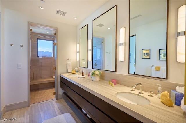 4915 Summit Overlook Dr, Las Vegas, NV 89135 - bathroom featuring a shower stall, double vanity, baseboards, wood finished floors, and toilet