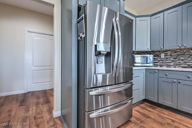 kitchen featuring backsplash, gray cabinets, dark hardwood / wood-style flooring, and appliances with stainless steel finishes