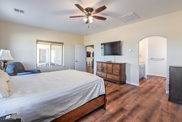 bedroom featuring ceiling fan, dark wood-type flooring, and connected bathroom