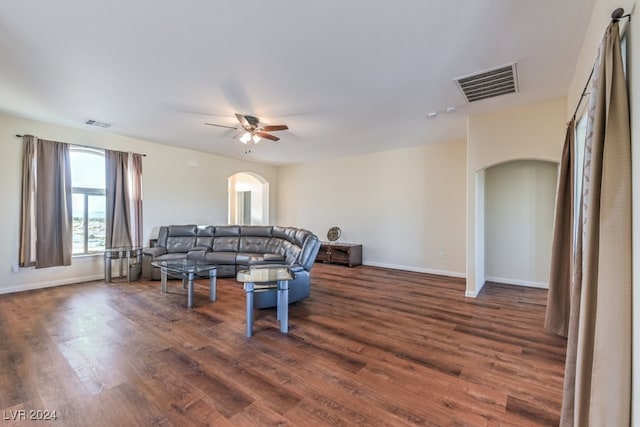 living room with ceiling fan and dark hardwood / wood-style flooring