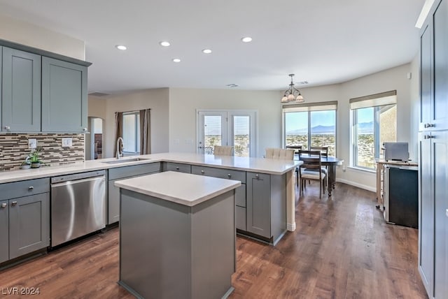 kitchen featuring gray cabinetry, a center island, sink, stainless steel dishwasher, and pendant lighting