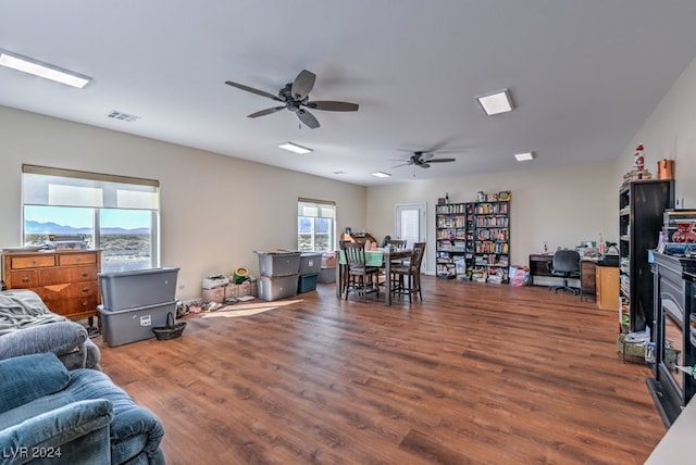 living room with ceiling fan, a healthy amount of sunlight, and dark hardwood / wood-style flooring