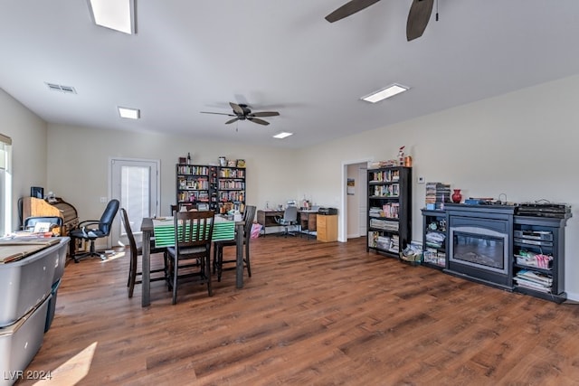 dining area with a fireplace, dark hardwood / wood-style flooring, and ceiling fan