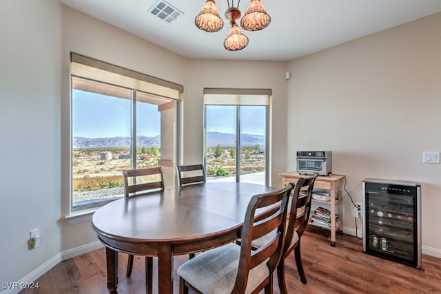 dining area featuring a chandelier, wine cooler, a mountain view, and wood-type flooring