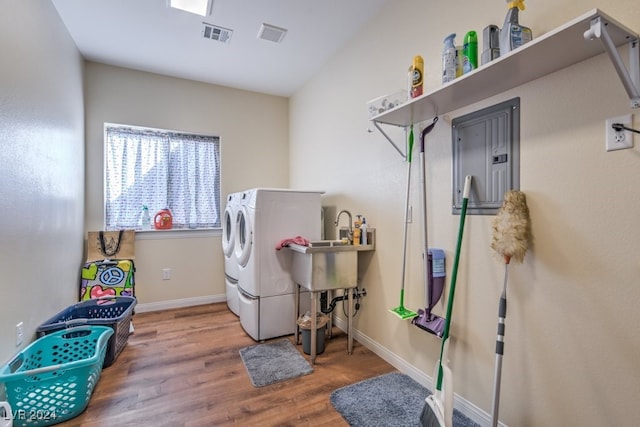 laundry area featuring independent washer and dryer, hardwood / wood-style flooring, and sink