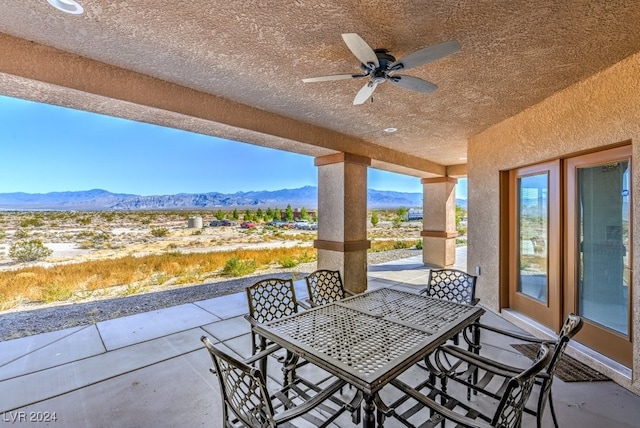 view of patio with a mountain view and ceiling fan