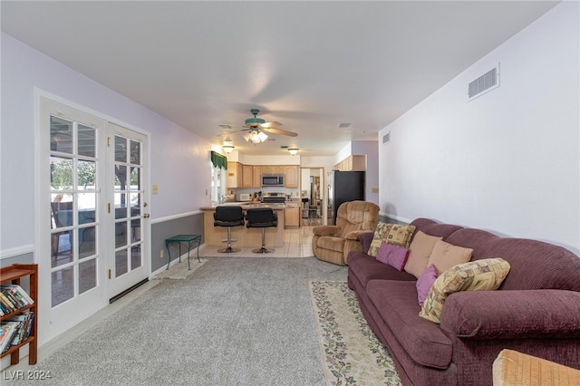 living room with light carpet, ceiling fan, and french doors