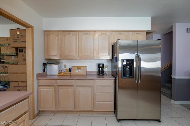 kitchen with light tile patterned floors, light brown cabinetry, and stainless steel fridge with ice dispenser