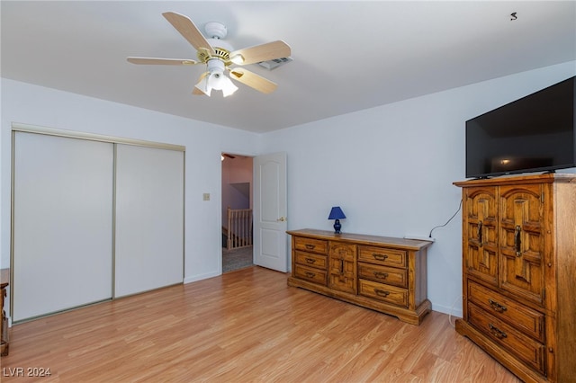 bedroom with ceiling fan, a closet, and light hardwood / wood-style floors