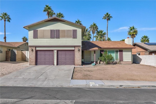 4020 Shadow Wood Ave, Las Vegas, NV 89121 - view of front facade featuring brick siding, a garage, fence, and driveway