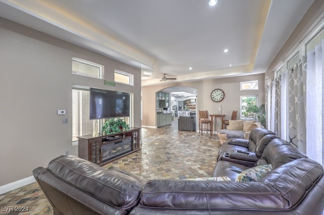 living area featuring arched walkways, ceiling fan, baseboards, and recessed lighting