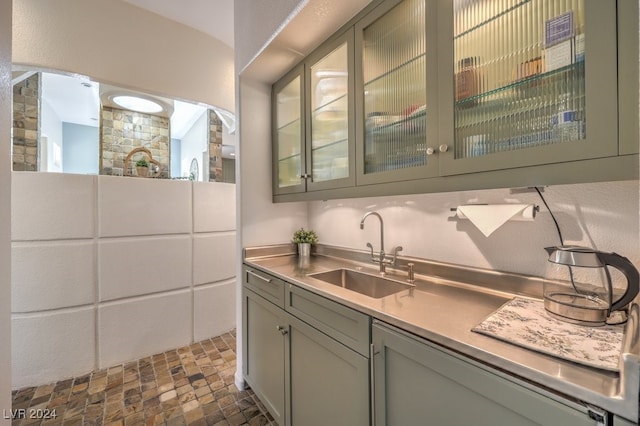 bar featuring a sink and stone finish flooring