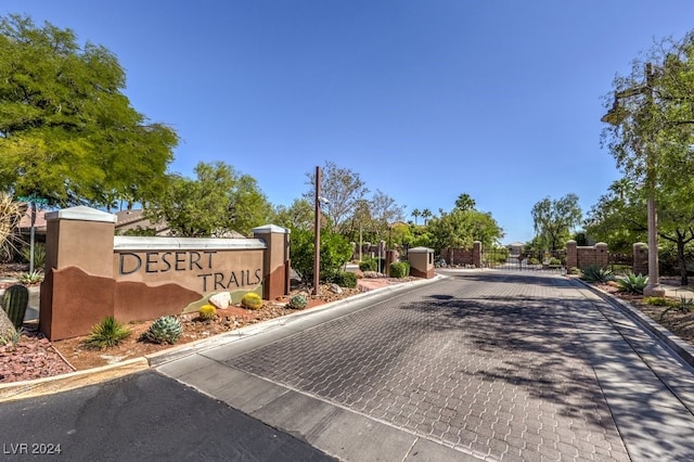 view of road featuring a gated entry, curbs, and a gate