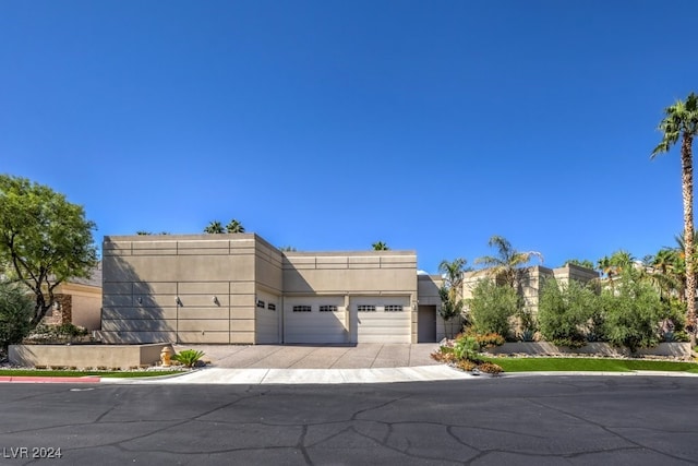contemporary house featuring a garage, driveway, and stucco siding