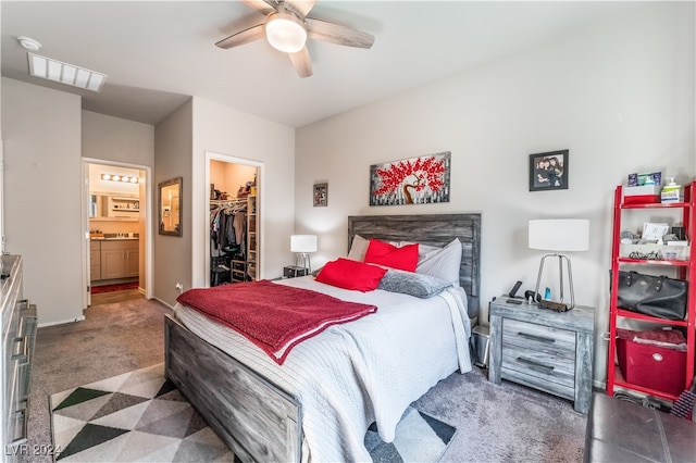 bedroom featuring dark colored carpet, a closet, ensuite bathroom, a spacious closet, and ceiling fan