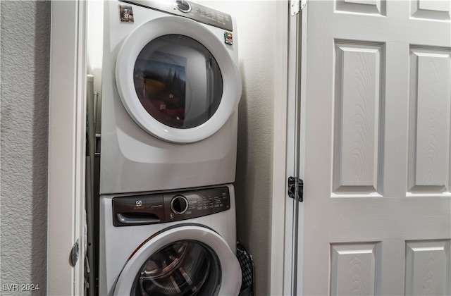 washroom featuring stacked washer / drying machine