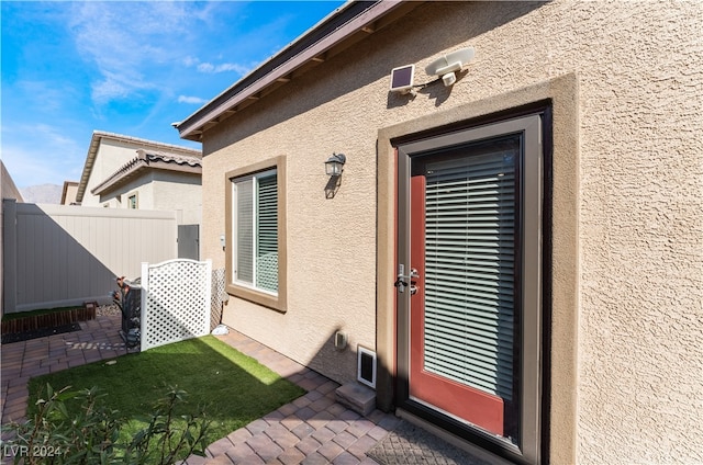 view of exterior entry with a patio