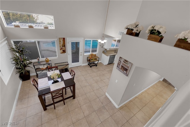 tiled living room with a chandelier and high vaulted ceiling