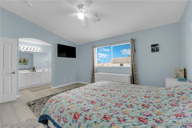 bedroom featuring connected bathroom, lofted ceiling, ceiling fan, and light wood-type flooring