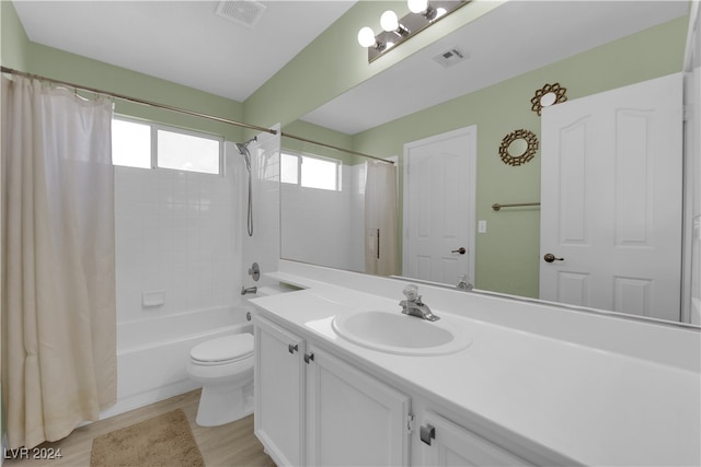 full bathroom featuring vanity, shower / bath combo with shower curtain, toilet, and hardwood / wood-style flooring