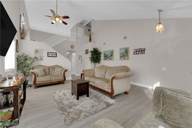 living room featuring ceiling fan, light hardwood / wood-style flooring, and high vaulted ceiling