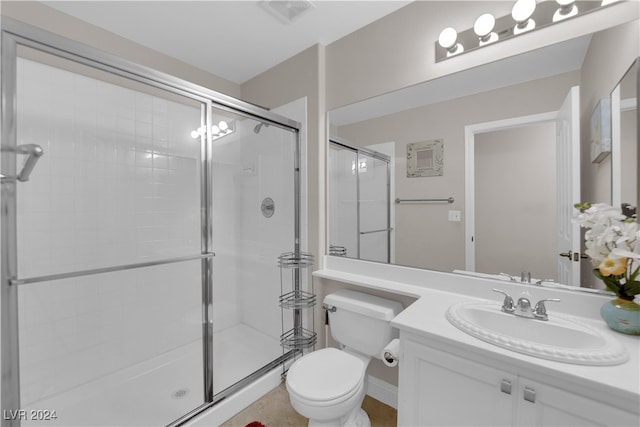 bathroom with a shower with door, vanity, and toilet