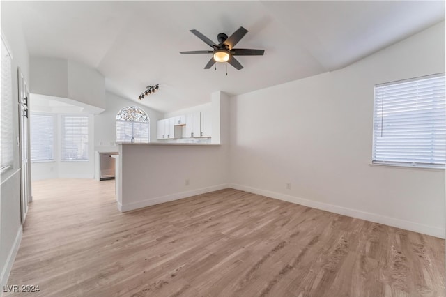 unfurnished living room with light wood-type flooring, vaulted ceiling, and ceiling fan