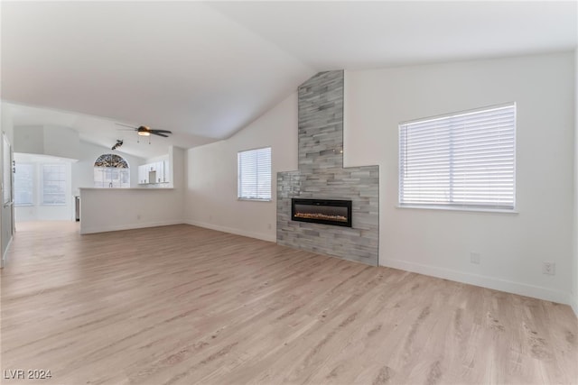 unfurnished living room with light hardwood / wood-style flooring, lofted ceiling, ceiling fan, and a fireplace