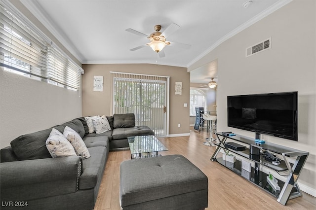 living room with light wood-type flooring, crown molding, ceiling fan, and vaulted ceiling