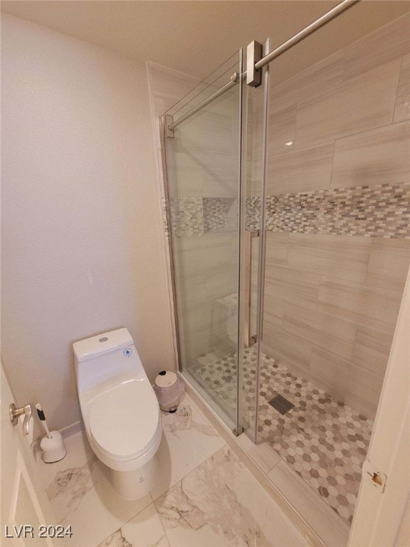 bathroom with a shower with shower door and toilet