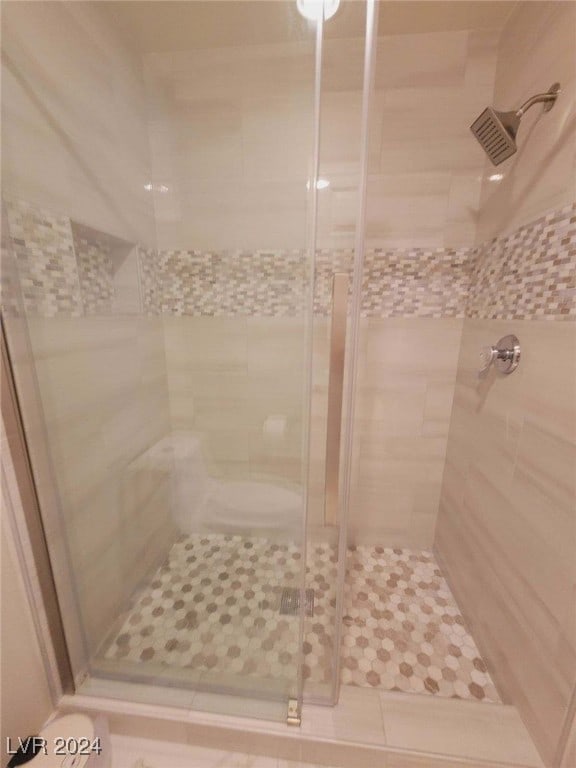 bathroom featuring a shower with shower door