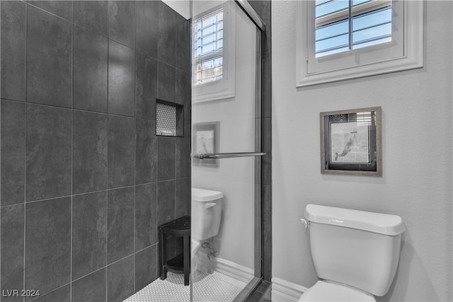 bathroom with toilet and an enclosed shower