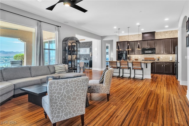 living room with light wood-type flooring and ceiling fan