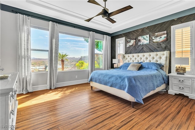 bedroom with multiple windows, light wood-type flooring, and ceiling fan