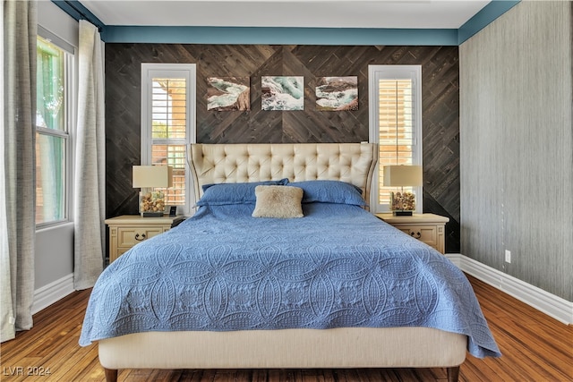 bedroom featuring light hardwood / wood-style floors and wood walls