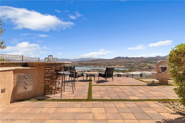 view of patio / terrace featuring a water and mountain view