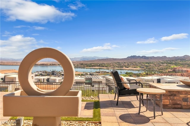 view of patio featuring a water and mountain view