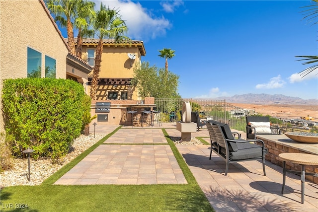 view of patio / terrace featuring exterior kitchen, a mountain view, and area for grilling