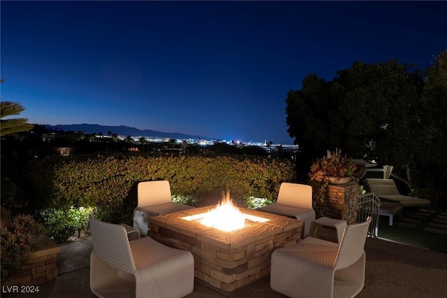 patio at twilight with a mountain view and a fire pit