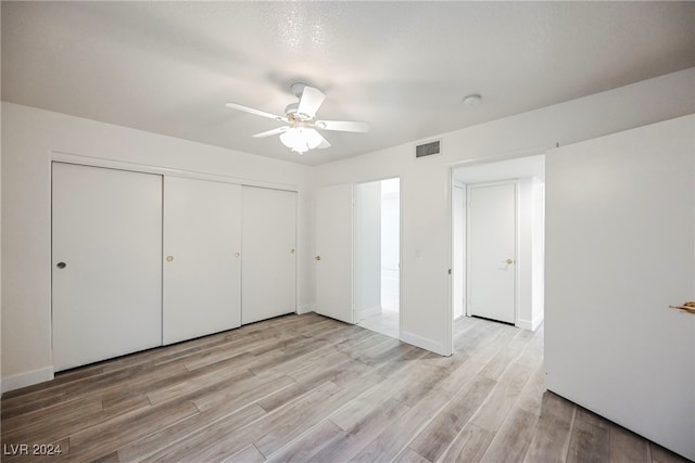 unfurnished bedroom featuring a closet, ceiling fan, and light hardwood / wood-style flooring