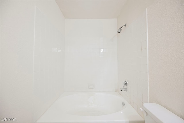 bathroom featuring tiled shower / bath and toilet